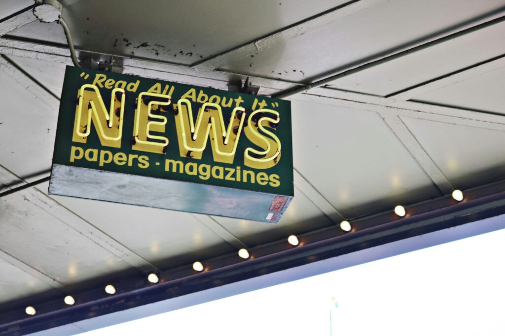 pexels-photo-1577882-1577882 From below of illuminated signboard with news papers magazines inscriptions hanging on metal ceiling on street