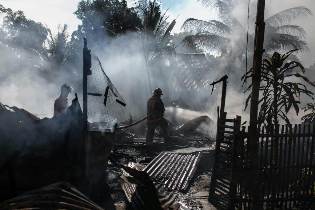 pexels-photo-942560-942560 Brave firefighters battle a blaze amidst thick smoke in an outdoor setting.
