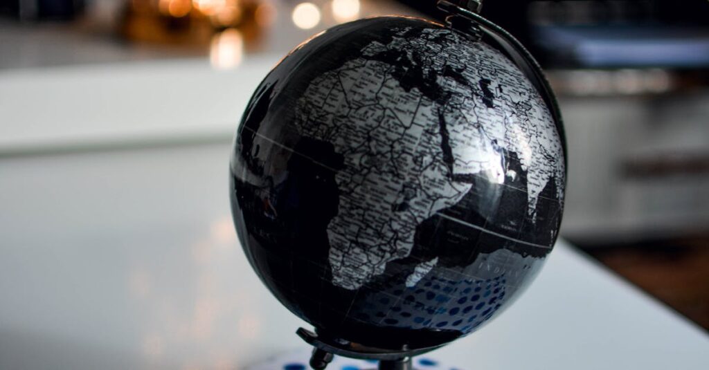 pexels-photo-1236421-1236421 Elegant black globe and notebook against warm bokeh lights, perfect for educational themes.